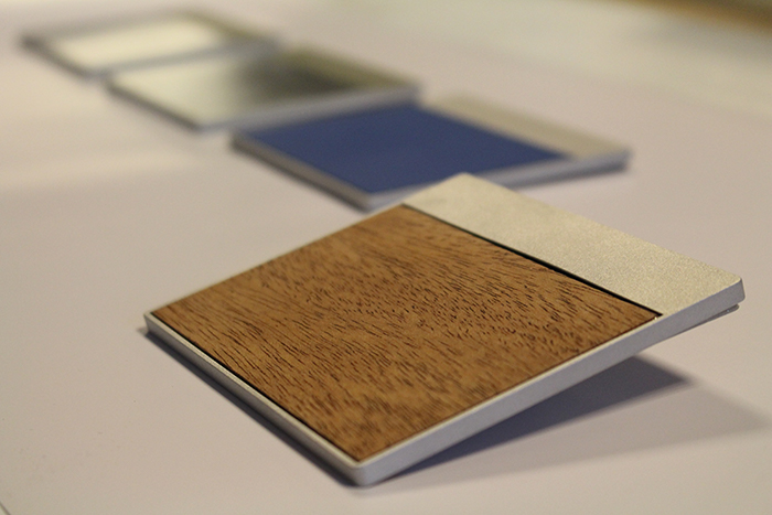 Embed haptic features in materials such as glass, wood, plastic, and metal.